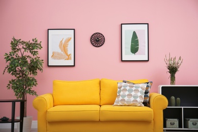 Photo of Modern living room interior with comfortable yellow sofa near color wall