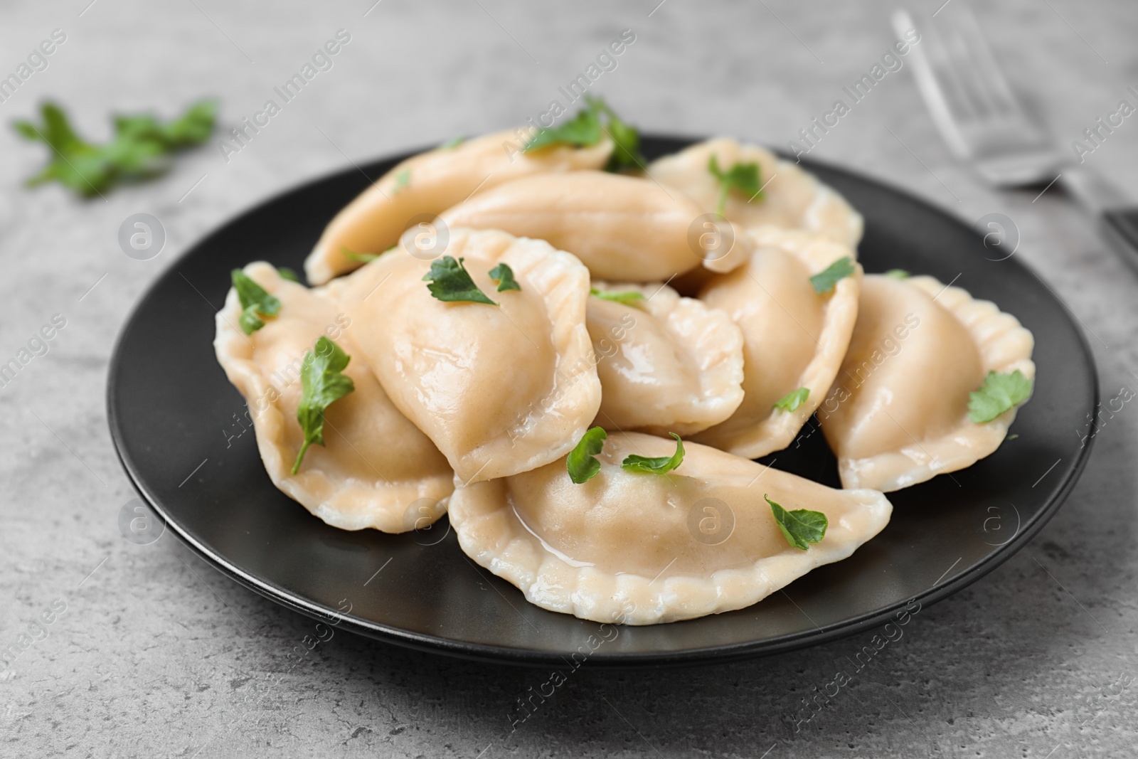 Photo of Plate of tasty cooked dumplings on stone surface