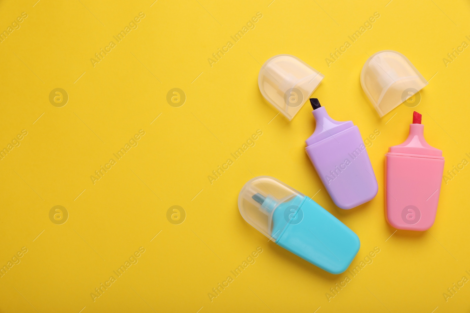 Photo of Many colorful markers on yellow background, flat lay. Space for text