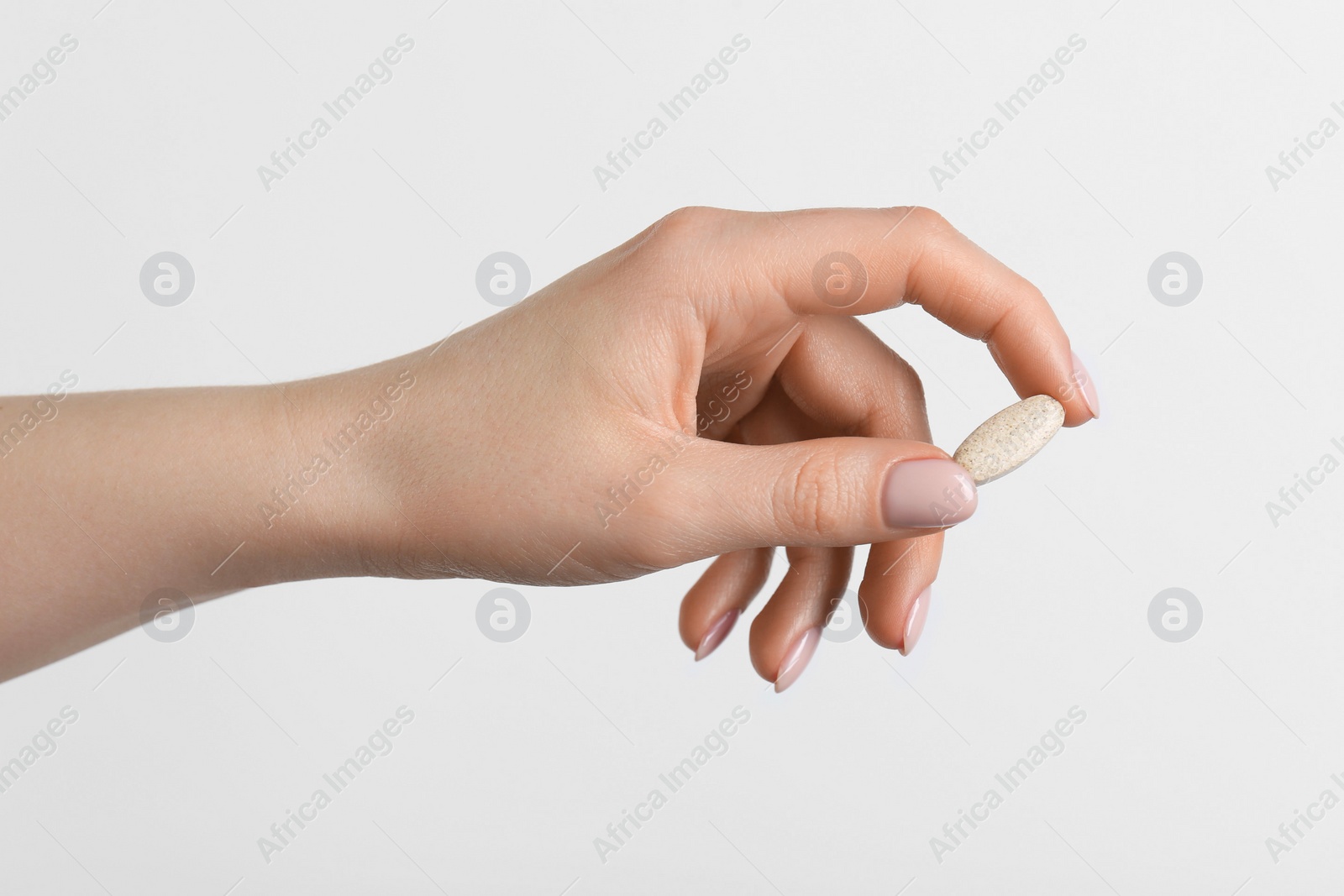 Photo of Woman holding vitamin pill on white background, closeup. Health supplement