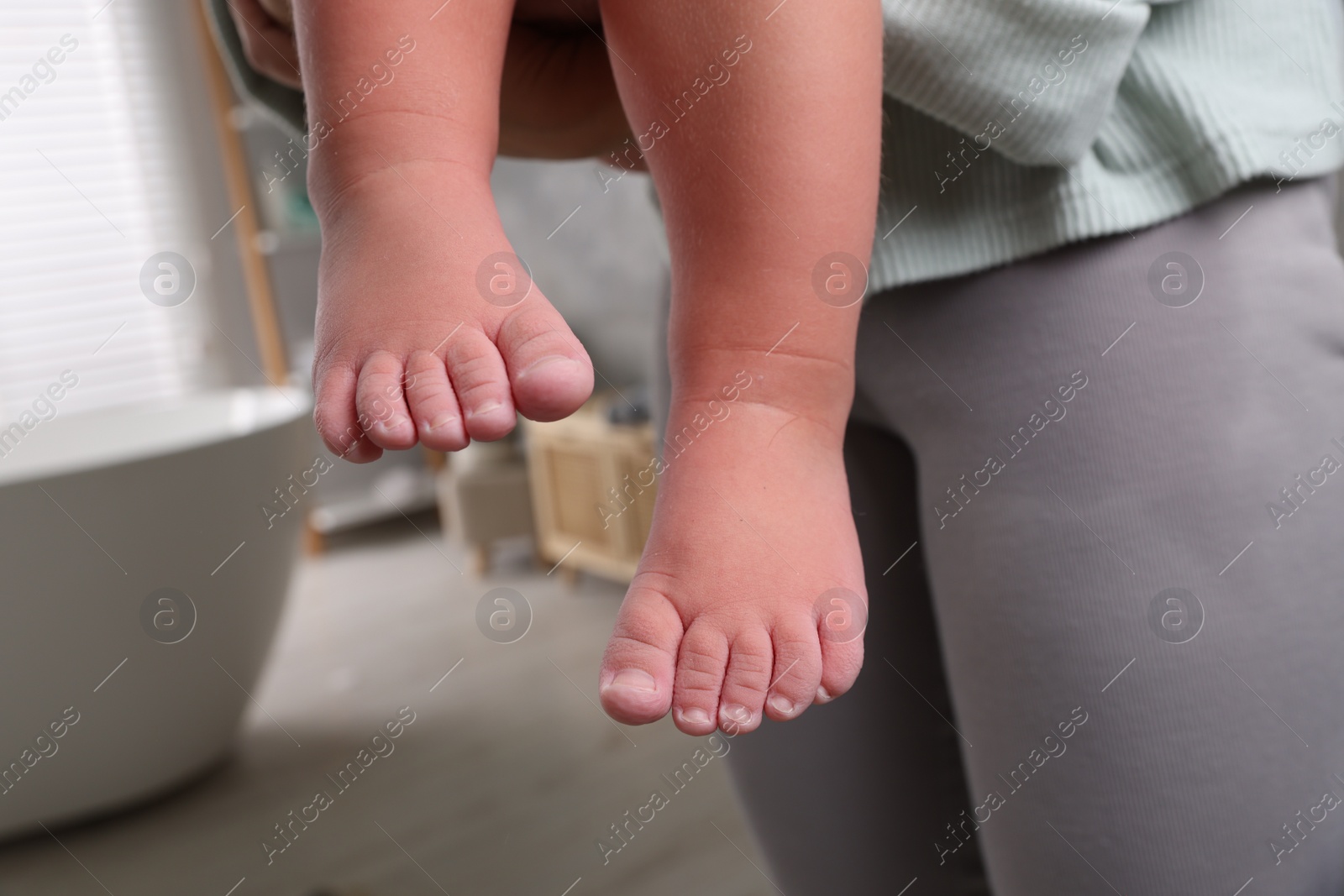 Photo of Mother with her daughter after bath, closeup. Focus on child`s feet