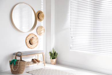 Photo of Stylish round mirror hanging on white wall in room