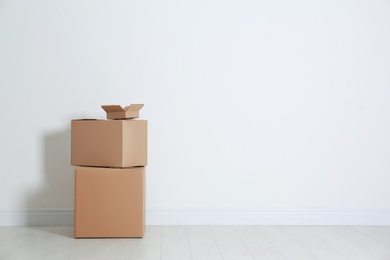 Photo of Cardboard boxes on floor near white wall