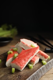 Photo of Fresh crab sticks with celery served on wooden table, closeup. Space for text