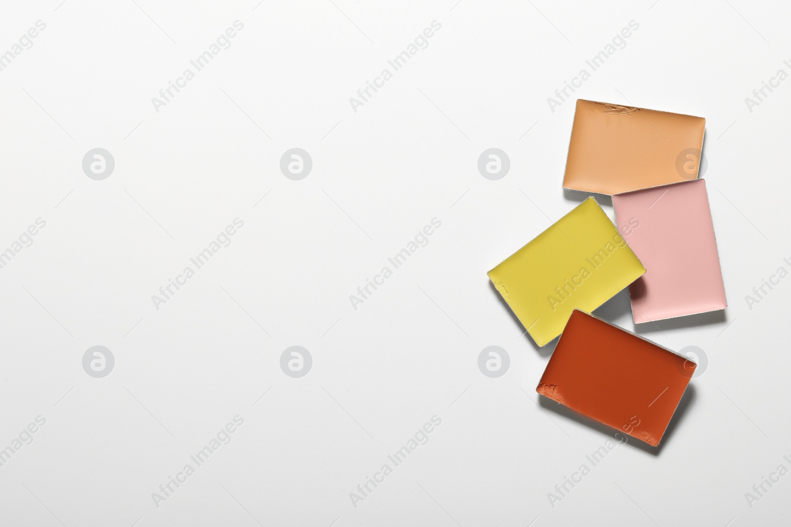 Photo of Different color correcting concealers on white background, top view