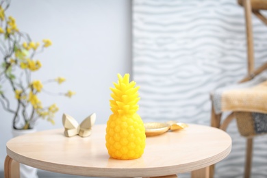 Photo of Pineapple shaped candle on table in room