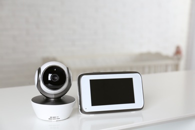 Photo of Baby monitor with camera on table in room. Video nanny
