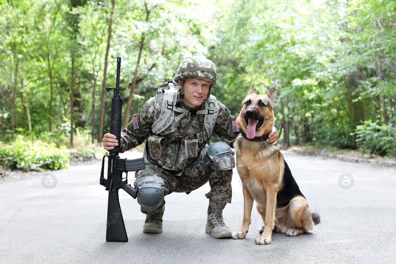 Photo of Man in military uniform with German shepherd dog, outdoors