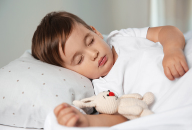 Photo of Cute little baby sleeping with toy at home. Bedtime