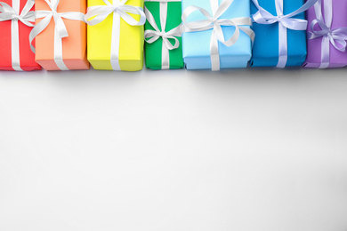 Photo of Bright gift boxes on white background, top view. Rainbow colors