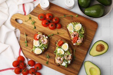 Photo of Delicious sandwiches with guacamole, shrimps and tomatoes on white table, flat lay