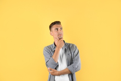 Photo of Thoughtful handsome young man on color background