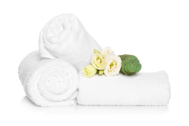 Photo of Soft terry towels with beautiful flowers and eucalyptus branch on white background