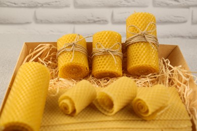 Photo of Beautiful yellow beeswax candles and sheets in box