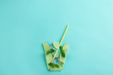 Photo of Creative lemonade layout with lemon slices, mint and ice on turquoise background, top view