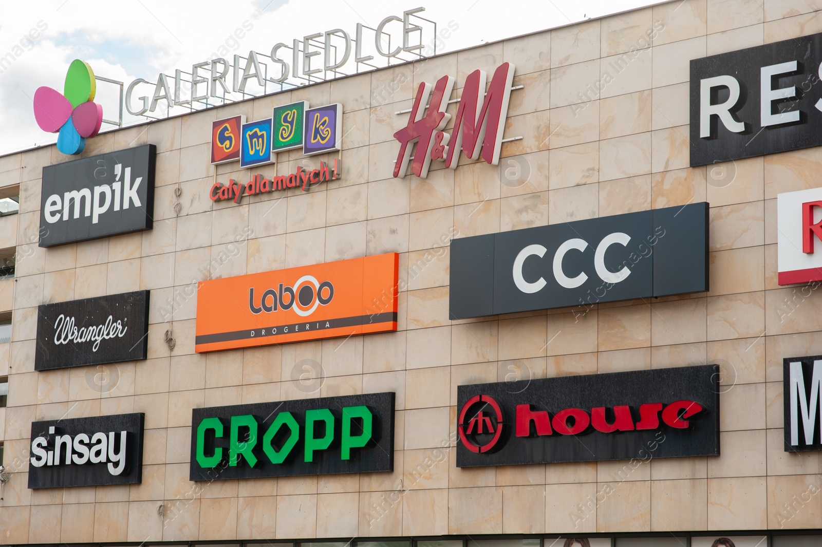 Photo of SIEDLCE, POLAND - AUGUST 30, 2022: Shopping mall with different store brand logos outdoors