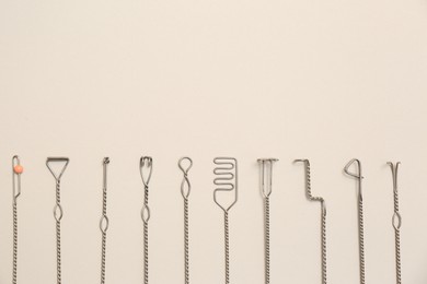 Photo of Set of logopedic probes for speech therapy on beige background, flat lay. Space for text