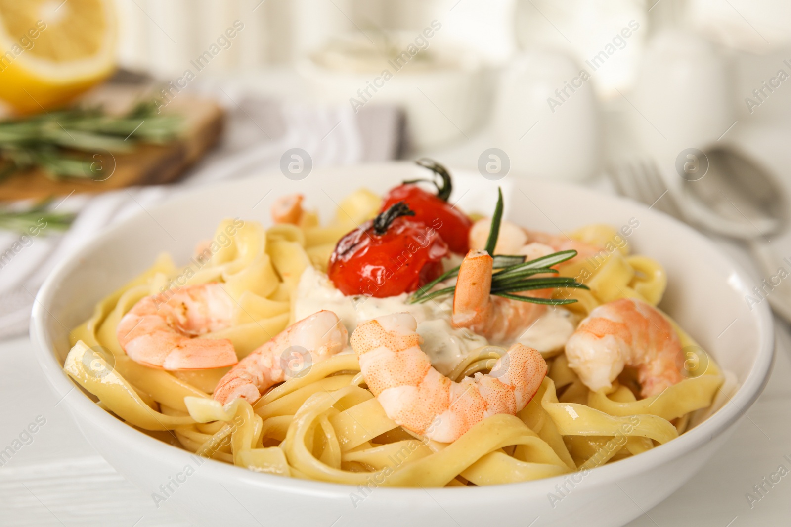 Photo of Delicious pasta with shrimps on white wooden table, closeup