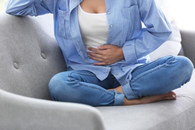 Young woman suffering from menstrual cramps at home. Gynecology