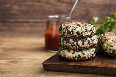 Photo of Delicious vegan cutlets with sesame on wooden table. Space for text