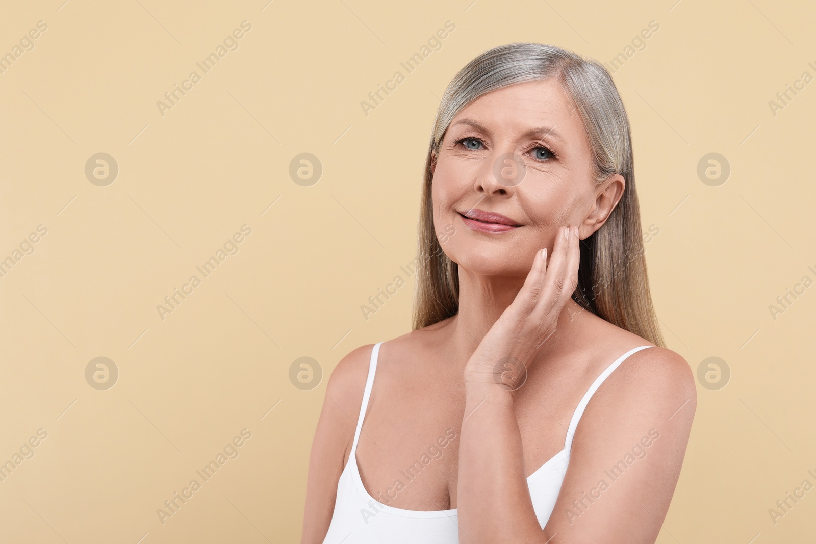 Photo of Portrait of beautiful senior woman on beige background. Space for text