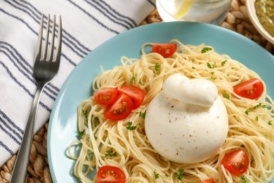 Plate of delicious pasta with burrata and tomatoes on table, closeup