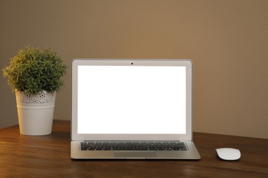 Laptop with blank screen on table indoors. Space for text