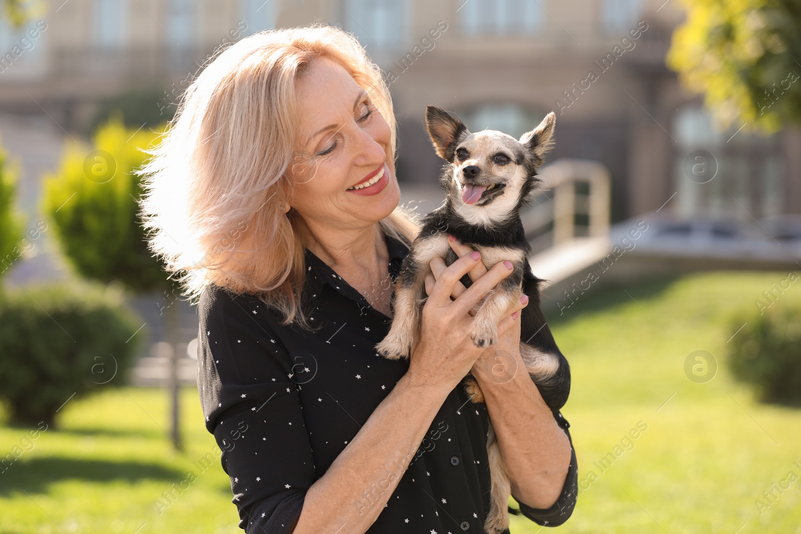 Photo of Beautiful mature woman with cute dog in park