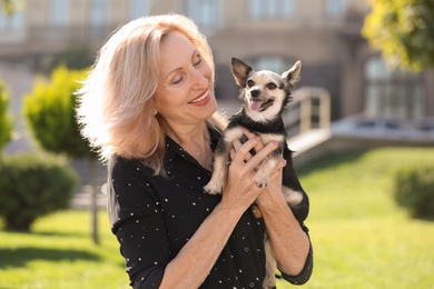 Beautiful mature woman with cute dog in park