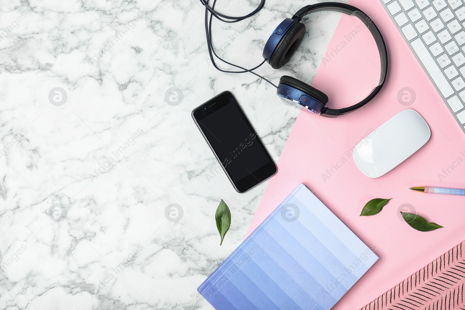 Photo of Flat lay composition with smartphone, computer keyboard, headphones and space for text on marble background