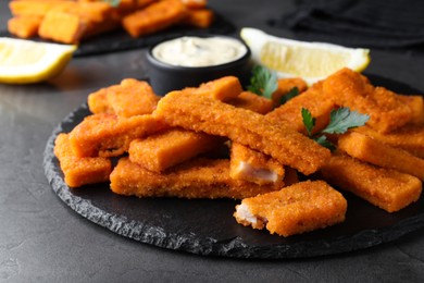 Photo of Tasty fresh fish fingers served on black table