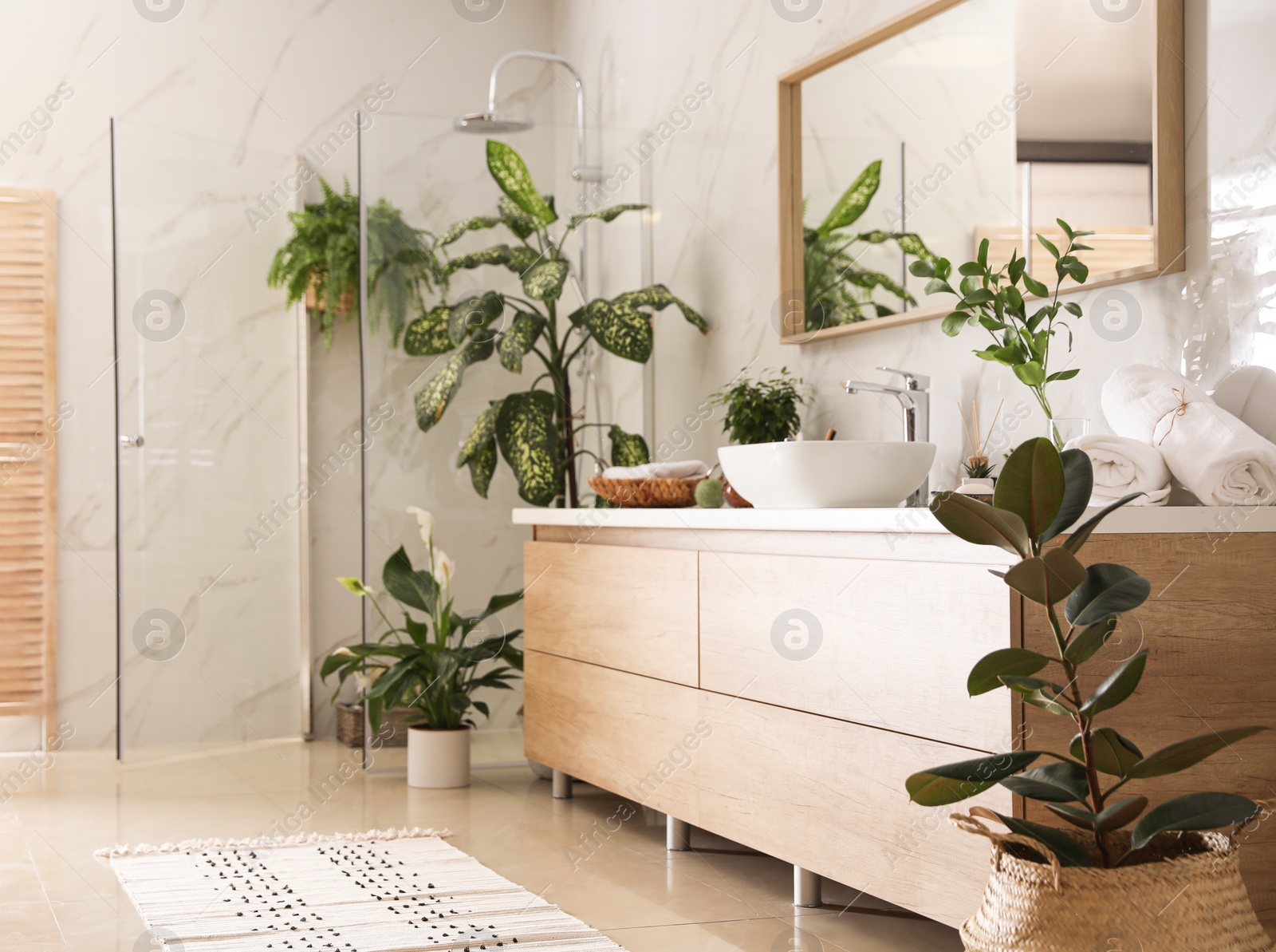 Photo of Beautiful green plants in elegant modern bathroom. Interior design