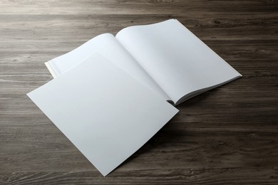 Sheet of paper and blank brochure on wooden table. Mockup for design