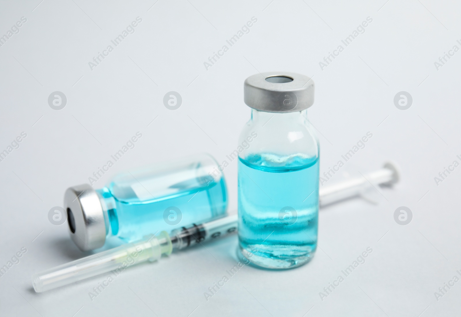 Photo of Vials and syringe on light background. Vaccination and immunization