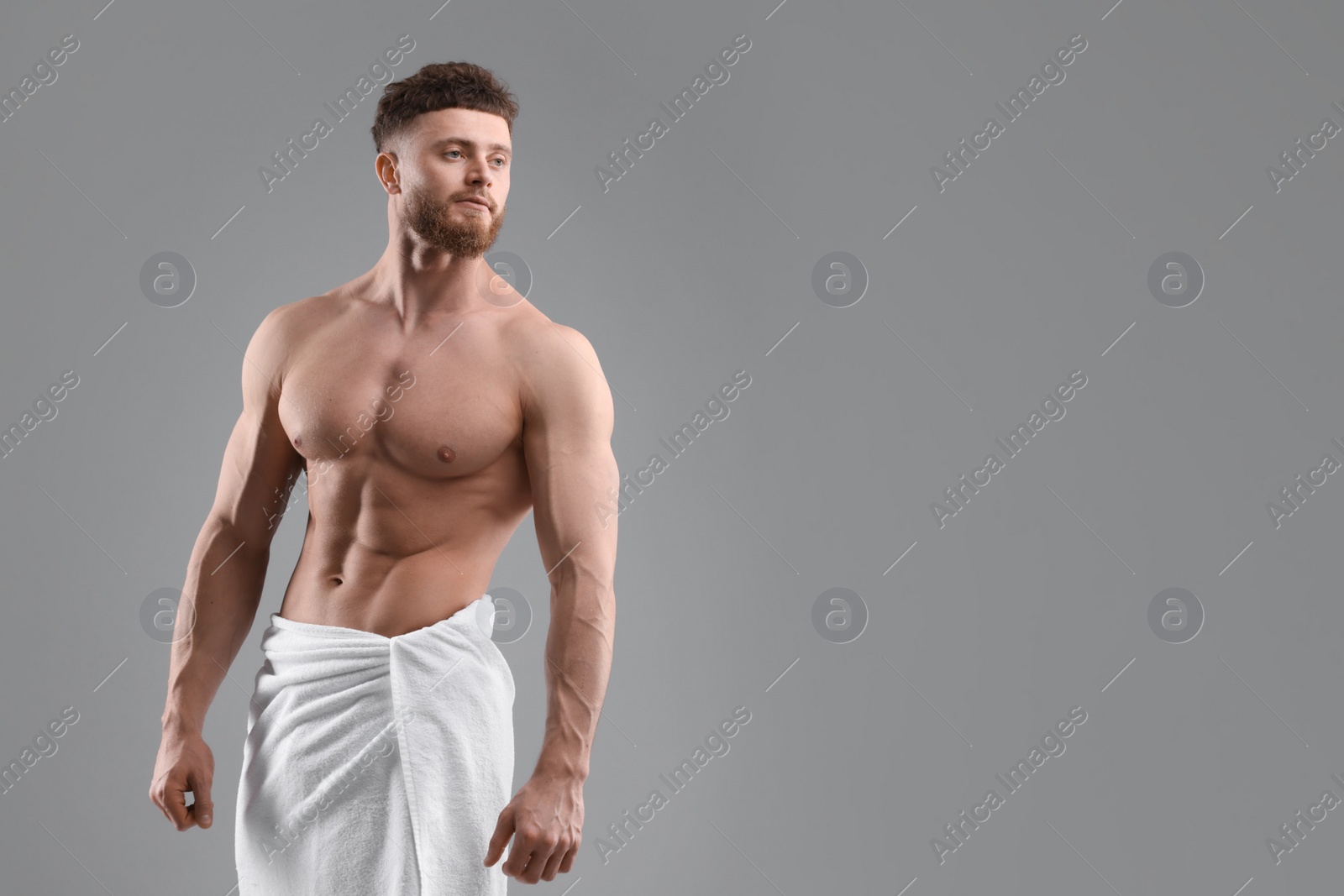 Photo of Muscular man showing abs on grey background, space for text