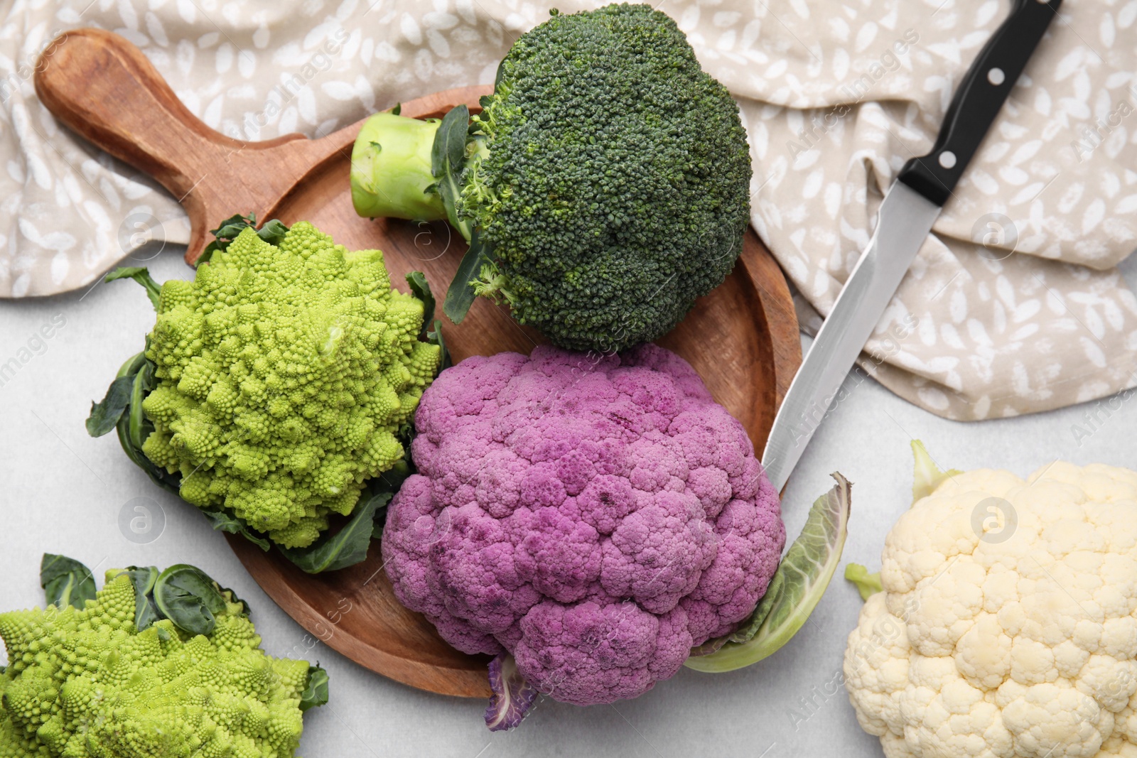 Photo of Different fresh cabbages on white table, flat lay