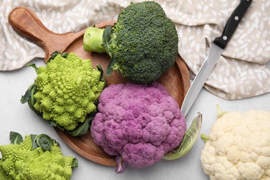 Different fresh cabbages on white table, flat lay