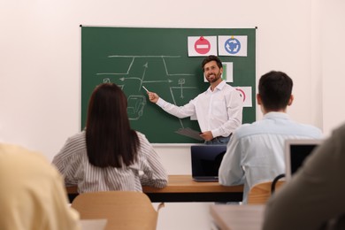 Teacher explaining traffic rules to audience during lesson in driving school