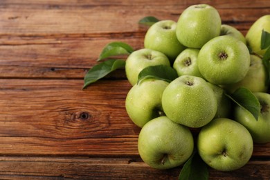 Fresh ripe green apples with water drops on wooden table. Space for text