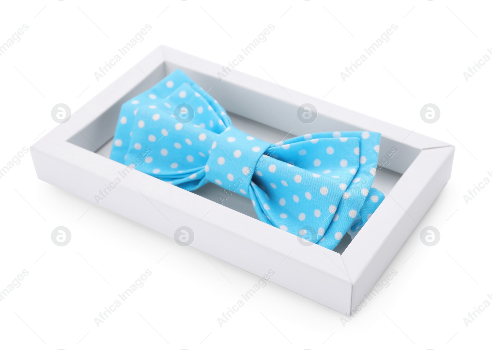 Photo of Stylish light blue bow tie with polka dot pattern in box on white background