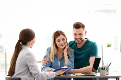 Photo of Young couple meeting with consultant in office