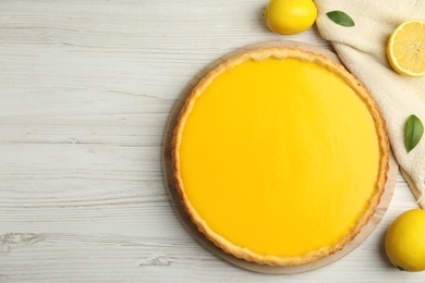 Delicious homemade lemon pie and fresh fruits on white wooden table, flat lay. Space for text