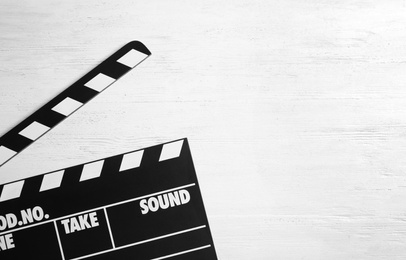 Clapperboard on wooden background, top view with space for text. Cinema production