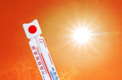 Image of Weather thermometer with high temperature outdoors on hot sunny day. Heat stroke warning