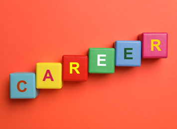 Photo of Colorful cubes with word CAREER on red background, flat lay