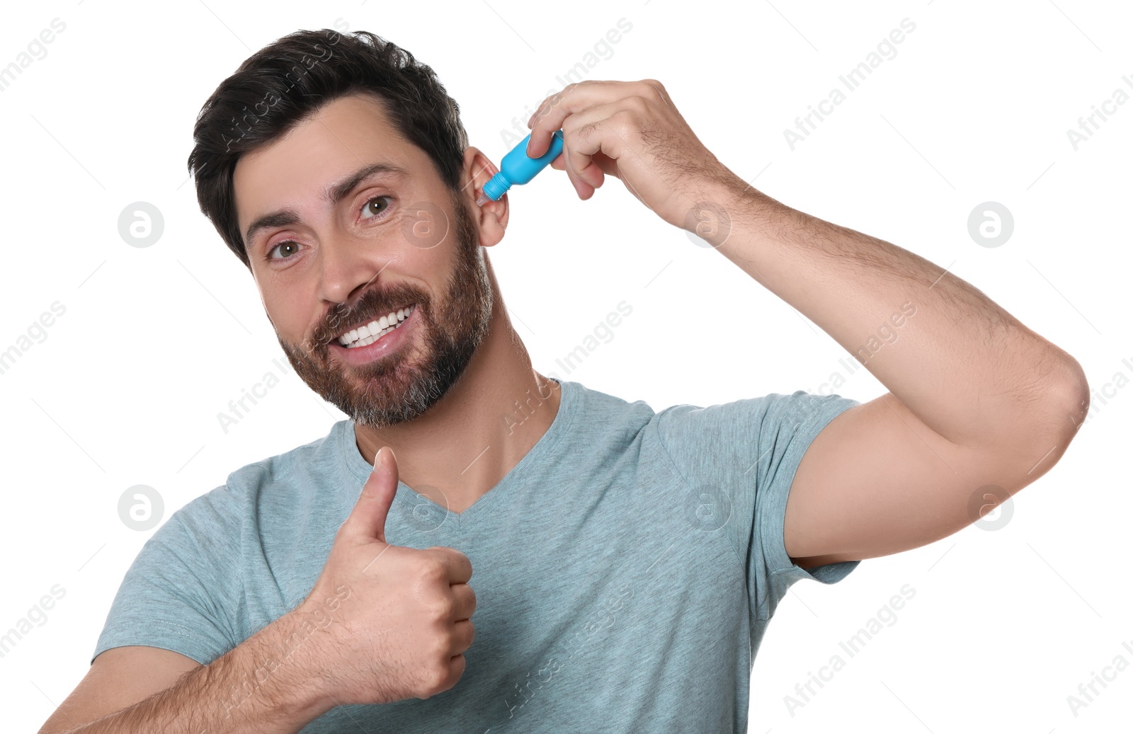 Photo of Man using ear drops and showing thumbs up on white background