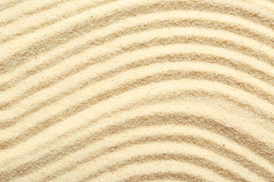 Photo of Zen rock garden. Wave pattern on beige sand, top view