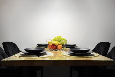 Photo of Table set for dinner near white wall