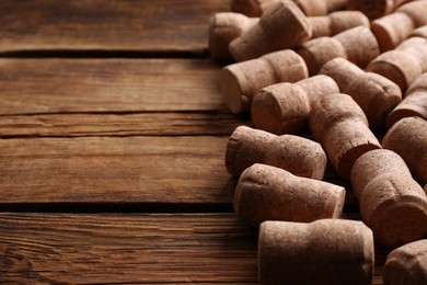 Photo of Sparkling wine bottle corks on wooden table. Space for text