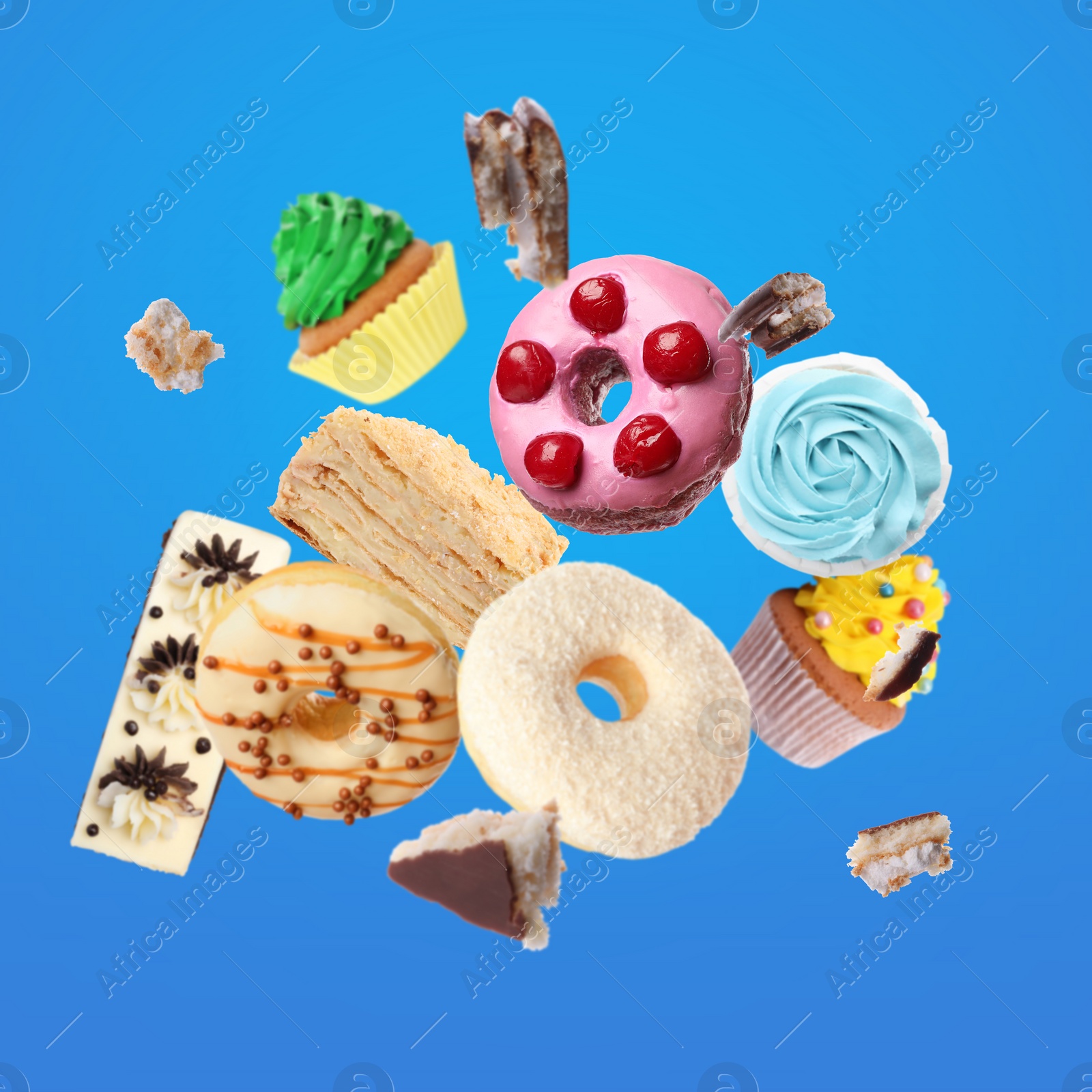 Image of Many different tasty desserts flying on blue background